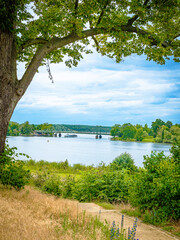 Blick vom Park Babelsberg auf die Havel und die Glienicker Brücke, am Tage bei leicht bewölktem blauen Himmel, vertikal