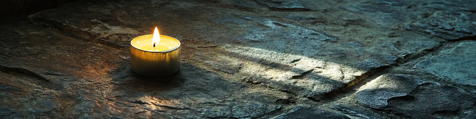 A dimly lit candle, casting shadows across a weathered stone floor.
