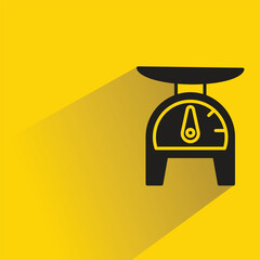kitchen weight scale with shadow on yellow background