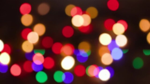 Christmas tree garland. Yellow, green, red and green lights. Defocused image, bokeh effect. Seamless looping