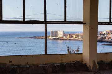 Abandoned hotel. Hotel Neptuno. Stairs, broken door, big tree and swimming pool in the background. Tenerife, Bajamar, Canary Islands.