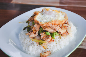 Pork with basil and fried egg on rice is ready to eat on the table.