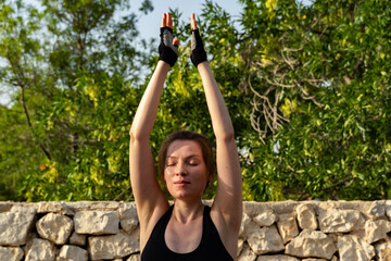 Young Woman Practicing Yoga Breathing Pose Outdoors Under The Sun
