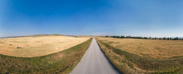 Dirt Road in Country side by farms. Alberta, Canada.