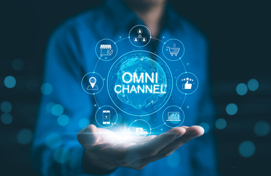 Omni Channel Marketing Concept. Businessman holding digital representation of omni-channel marketing, e-commerce, delivery, social media, analytics, customer engagement, and customer service icons.