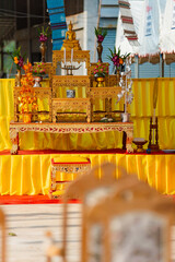 A set of golden altar tables and Buddha seats in religious ceremonial homes. There is a Buddha image placed on the worship table. Thai culture and religion in Thailand