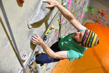 young sporty man bouldering in a climbing hall - indoor sports © industrieblick