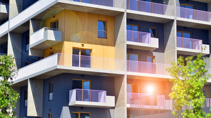 New modern block of flats in green area. Eco apartment building saving energy and fresh air concept. Green tree and new apartment building. The harmony of nature and modernity.