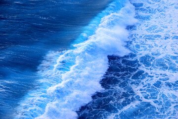 Fototapeta premium Turquoise ocean sea water white wave pattern splashing deep blue sea. Seascape dark ocean background wave splash on rock. Tropical sea beach in summer seaside outdoor. Water Surface blue wave pattern