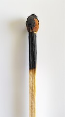 Burnt matchstick close-up on white background, symbolizing burnout, exhaustion, risk, and danger
