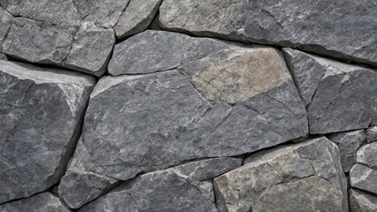 Fototapeta premium Close-up of a dry stone wall with irregularly shaped gray stones tightly stacked together. The image showcases the rough texture and natural patterns of the stones, ideal for backgrounds