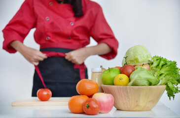 Close up Females Chef hands holding chop Wooden cutting board home kitchen. Women Chef hand cutting slice red tomato prepare fruit vegetables. Crop Woman hands use knife chopping organic tomato