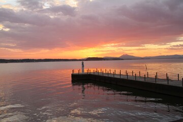 Obraz premium Lighthouse at Sunset with Colorful Sky and Lake Reflection in Japan