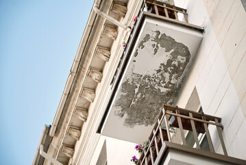 Old balcony with plaster and piant chunks and fall off needs for repair. Balcony and facade with...