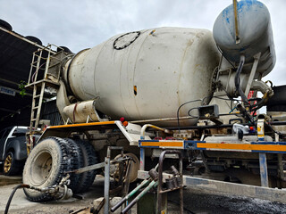 A concrete mixer truck parked beside of a concrete factory