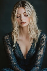 Naklejka premium blonde woman in a blue lace dress with folded hands meditating