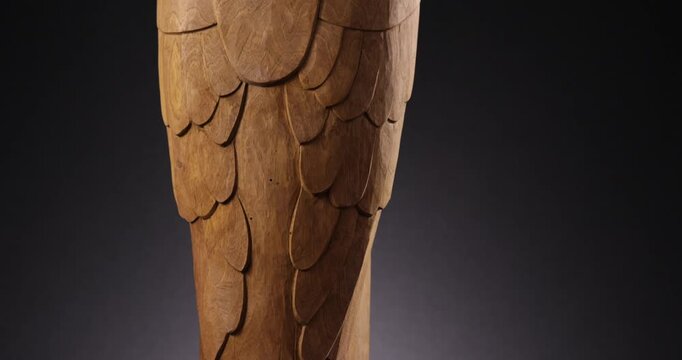 Detailaufnahme einer alten Holzskultpur eines Adlers Raubtier Greifvogels vor schwarzem Hintergrund 