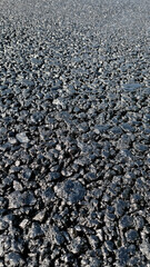 New laid asphalt road, large crushed stone.  Close-up. Background.