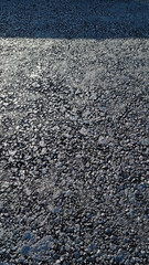 New laid asphalt road, large crushed stone.  Close-up. Background.