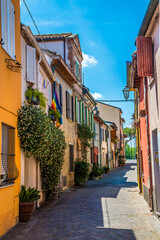 A view down a narrow, colourful street in the village area of San Giuliano in Rimini, Italy in summertime