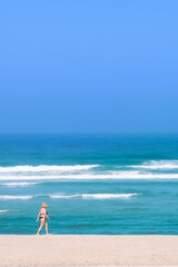 minimalism on the beach, with a sea in the background and an isolated person on one side