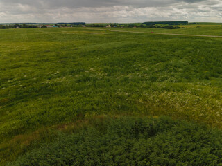 Obraz premium Landscape view from drone, yellow and green fields and haystacks, sky with white clouds. 
