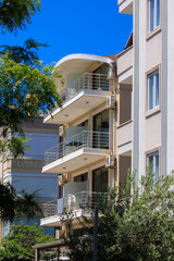 Obraz premium City view on a sunny day. Modern building and houses against the blue sky.