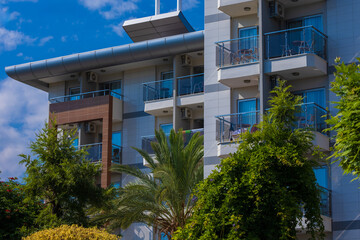 Obraz premium City view on a sunny day. Modern building and houses against the blue sky.