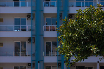 City view on a sunny day. Modern building and houses against the blue sky.