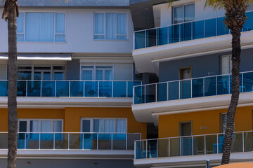 City view on a sunny day. Modern building and houses against the blue sky.