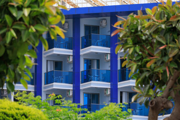 City view on a sunny day. Modern building and houses against the blue sky.