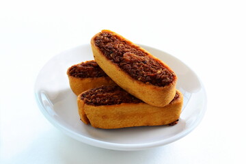 Indian gujarati traditional spice stuffed tea time Snacks food Bhakarvadi or Bakarvadi samosa in dish Diwali snacks Bhakharwadi in white background,top view