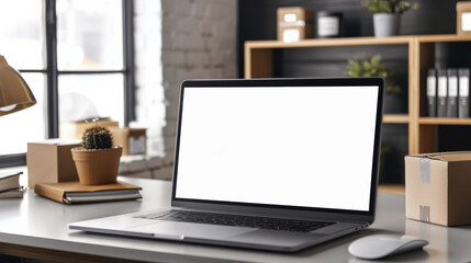 A laptop in a modern workspace with boxes and office supplies in the background.