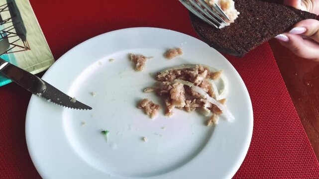 A view of the hands of a girl who prepares a local dish for herself - stroganina from pelamis