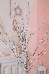A minimalist winter decoration featuring a branch with tiny white lights, bringing a subtle glow to holiday interiors.
