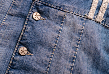 Detailed shot of a blue denim jacket with metal buttons