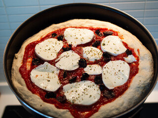 Italian Neapolitan pizza with mozzarella cheese ready to go in the oven