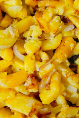 Fried potatoes with onions. Close-up, top view. Vertical photo.