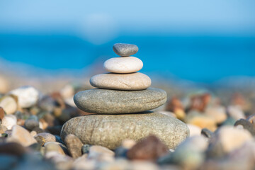 A pyramid of stones on a pebble beach by the sea, the concept of balance, balance, tranquility, relaxation