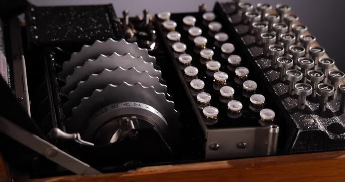 Detailaufnahme einer alten historischen Enigma Schreibmaschine zur Decodierung und versenden von verschl&uuml;sselten Nachrichten zu Zeiten des zweiten Weltkriegs vor schwarzem Hintergrund