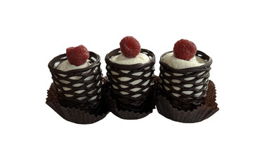 Three chocolate and cream desserts with raspberry isolated on white
