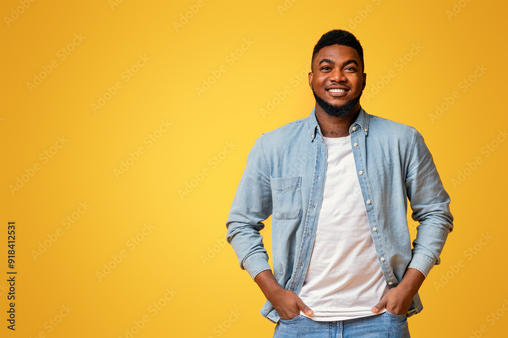 Aufkleber portrait of confident african american man standing with hands in pockets on yellow background with 