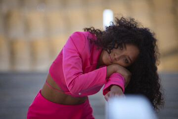Portrait of woman, young, beautiful, latina, brunette with curly hair, with pink jacket suit, with...