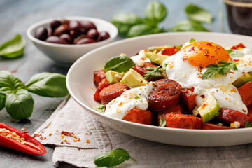 Sweet Potato and Chorizo Hash with egg, avocado and herbs.
