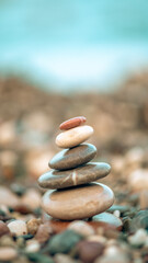 A pyramid of stones on a pebble beach by the sea, the concept of balance, calm, tranquility, relaxation with copy space