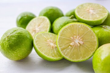 Several lime with sliced lime on a white background