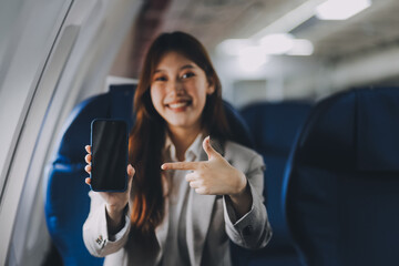 A young Asian woman, seated as an airplane passenger, contemplates dollar bills, reflecting on lucrative opportunities and aspirations towards billionaire status.