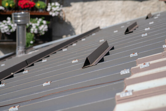 particular sheet metal roof with snow-breaking elements. roof building in the mountains with profile detail, metal shapes roof element