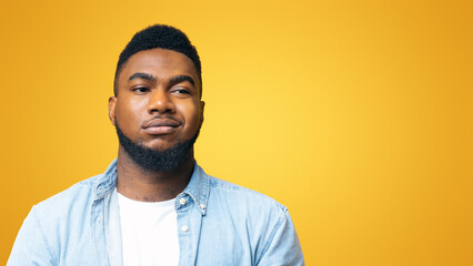 Portrait of african american man with sceptical face expression over yellow background with copy space