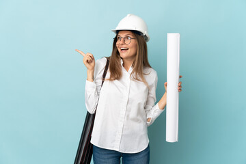 Slovak architect girl holding blueprints isolated on blue background intending to realizes the solution while lifting a finger up